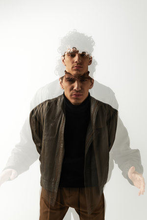 Young man in a stylish jacket poses confidently, featuring a dynamic double exposure.