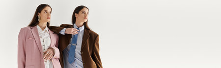 Twin sisters elegantly pose, dressed in fashionable outfits, radiating confidence and style.