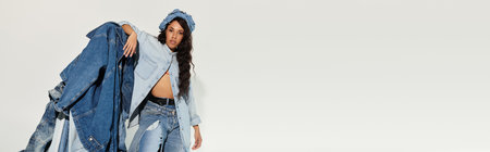 A young woman expresses her creativity in denim clothing while enjoying the summer sun.のeditorial素材