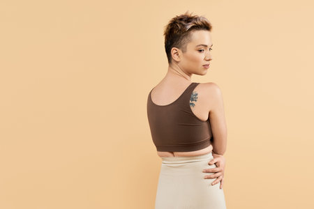 Woman with short hair showcases body positivity and confidence in a stylish outfit.のeditorial素材