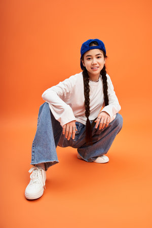A young girl showcases her trendy outfit and playful style in a bright studio, exuding confidence.のeditorial素材