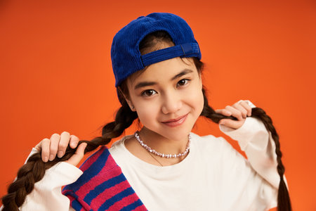 With a playful smile, a teenage girl showcases her unique style in a vibrant studio backdrop.