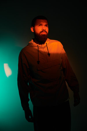 A young man stands confidently, illuminated by warm hues, embracing the summer vibe.