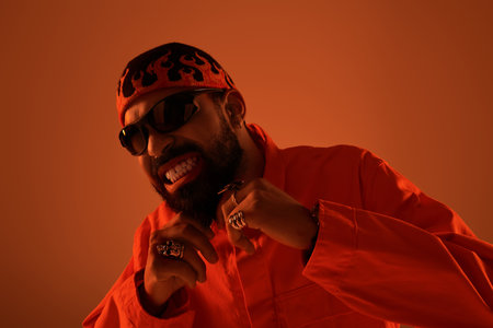 Handsome man showcases a bold summer outfit while confidently posing against a warm backdrop.の写真素材