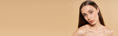 Beautiful woman with long hair showcases summer style against a warm, neutral background.のeditorial素材