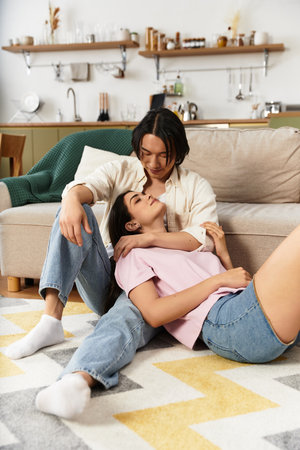 A couple shares a tender moment sitting on the floor, enveloped in love and affection at home.