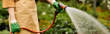 A young woman nurtures her plants with care in a sunny greenhouse, bannerの写真素材