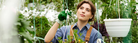 Young woman joyfully tending colorful plants in a sunny greenhouse, banner