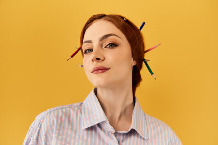 This beautiful young woman showcases her playful spirit with colorful pencils in her hair.の写真素材