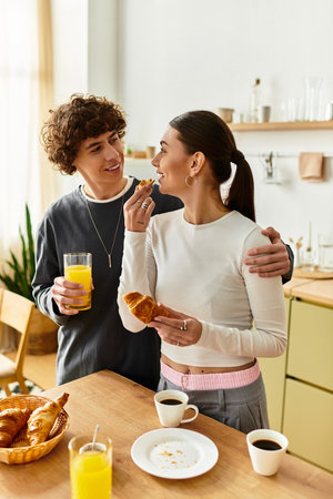 A happy couple shares breakfast in their bright kitchen, feeding each other treats.の写真素材