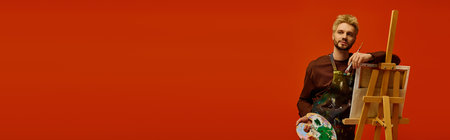 Young artist stands confidently with a palette in hand, showcasing his creative spirit and style.のeditorial素材