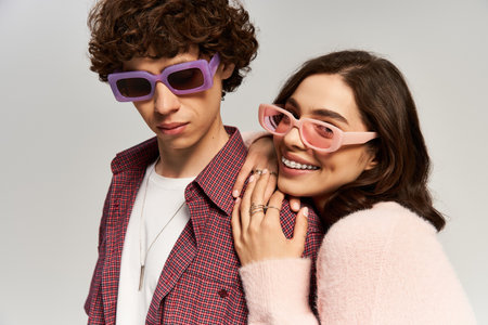 A fashionable man and woman embrace, radiating love and joy, showcasing their trendy outfits.の写真素材