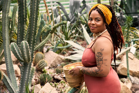 A joyful African American woman with braids enjoys her time surrounded by lush greenery.のeditorial素材