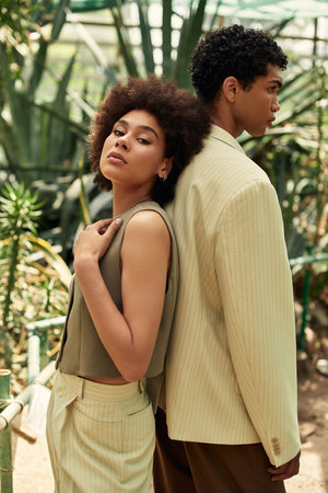 A happy young couple shares their love in a vibrant greenhouse full of plants.