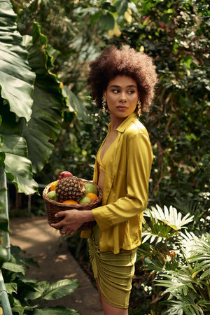A pretty woman enjoys time in a lush greenhouse filled with greenery and plants.の写真素材
