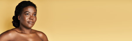 A young African American woman with stunning skin poses confidently in a vibrant studio, bannerの写真素材
