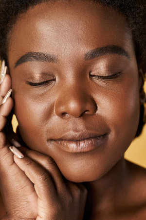 A young Black woman shines in a studio, embracing her natural beauty.の写真素材