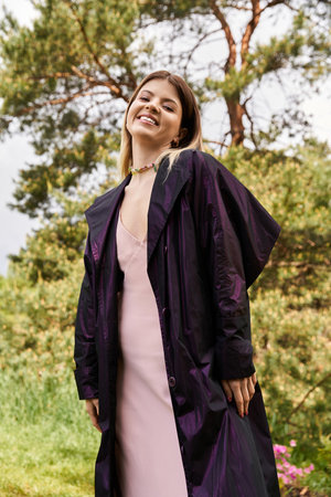 Smiling woman in pink dress  coat in forest.の写真素材