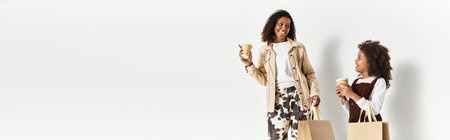 African american mother and daughter enjoy playful moments while showcasing their fashionable looks,...