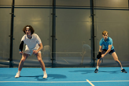 Young sportsmen engage in a thrilling padel game, showcasing their skills and coordination.の写真素材