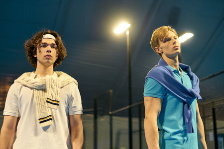 Young men engage in an intense padel match, displaying athletic skill and teamwork on court.