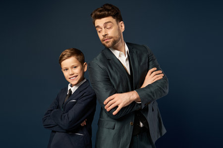 A father and son share a joyful moment, each dressed elegantly, showcasing togetherness and pride.