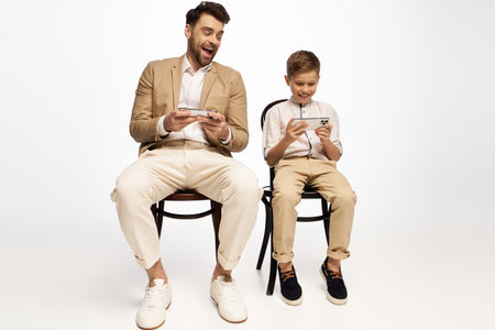 Father and son enjoying a playful gaming session, bonding and celebrating Fathers Day joyfully.の写真素材