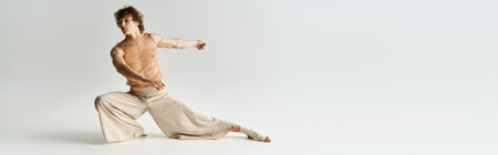 Young athletic man showcases dynamic dance moves in an empty studio space, embracing his art, bannerの写真素材