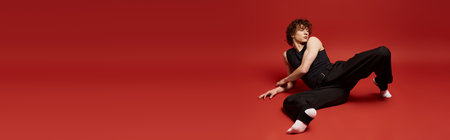 A young man showcases his dance moves with passion against a striking red background, bannerの写真素材