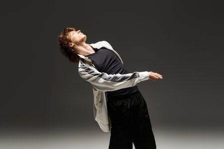 A young curly man gracefully dances in a studio, showcasing athletic skill and passion.の写真素材
