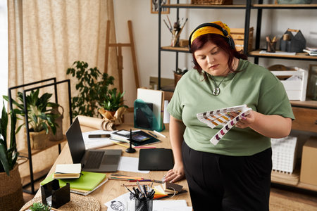 A pretty woman explores vibrant colors while surrounded by artistic materials in her studio.の写真素材