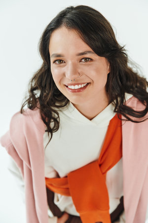 Fashionable young woman smiles confidently in a chic outfit, showcasing her unique style.