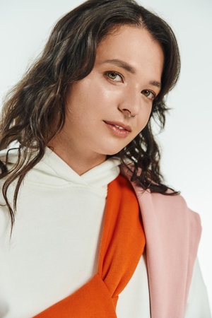 Young woman radiates confidence in fashionable attire, showcasing a modern urban vibe.
