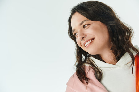 Young woman with a bright smile wears trendy clothes, radiating style and confidence.の写真素材
