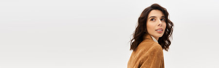 Young woman in stylish outfit strikes a pose in suede blazer against a grey backdrop, bannerの写真素材