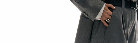 Young woman confidently presents her fashionable outfit while standing against a bright backdrop.の写真素材