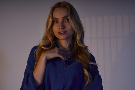 A beautiful young woman poses elegantly in a chic outfit, exuding modern fashion and charm.の写真素材