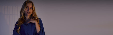 A fashionable young woman poses elegantly, displaying her trendy outfit in a stylish urban setting.の写真素材