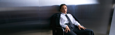 A stylish young woman sits gracefully, exuding elegance and confidence.