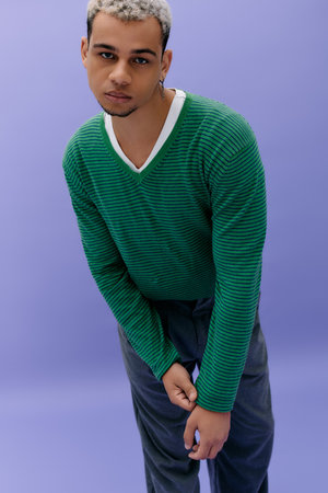 Young African American man poses confidently in a trendy outfit, radiating style and charisma.