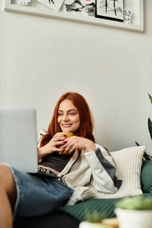 A young woman relaxes on a couch, smiling while enjoying her drink.