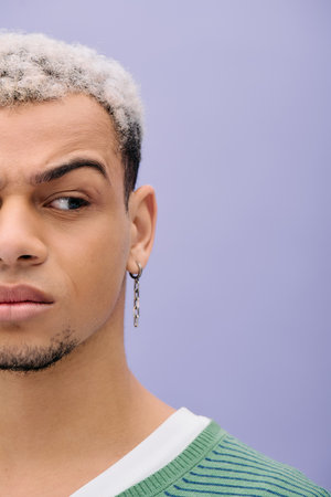 A young Black man with dyed hair poses confidently in a stylish outfit, embracing diversity.の写真素材