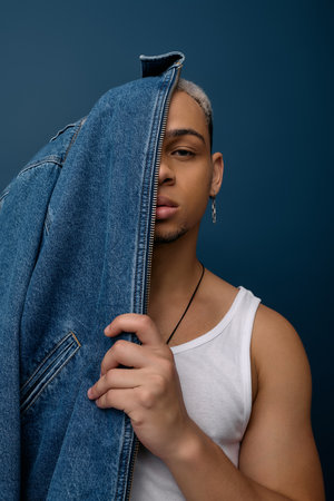 A young Black man shows off his style in a denim jacket, highlighting his individuality.の写真素材