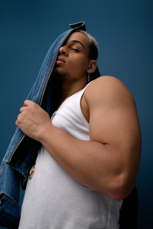 A young man with dyed hair poses confidently in a denim jacket, exuding modern style.の写真素材