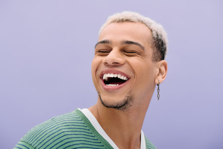 A young african american man with dyed hair smiles confidently while posing fashionably.