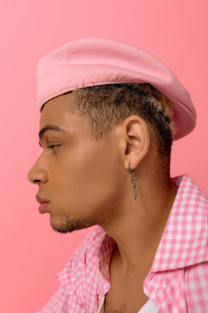 A young African American man showcases his fashion with a stylish beret and checkered shirt.