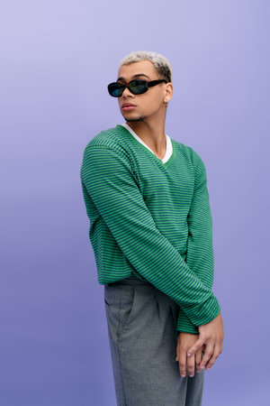 A young man with dyed hair showcases a trendy outfit, exuding fashion flair on a vibrant background.