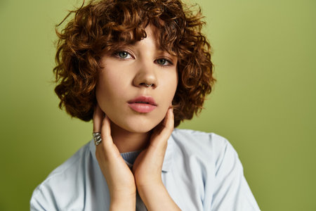 A young woman with short curls poses in a stylish summer outfit against a green backdrop.