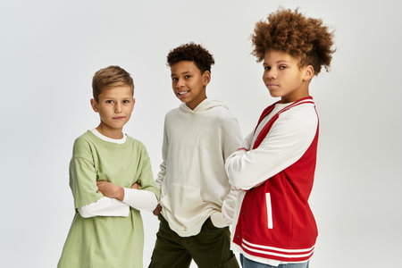 Three cute boys in stylish, colorful outfits confidently celebrate their bond.の写真素材