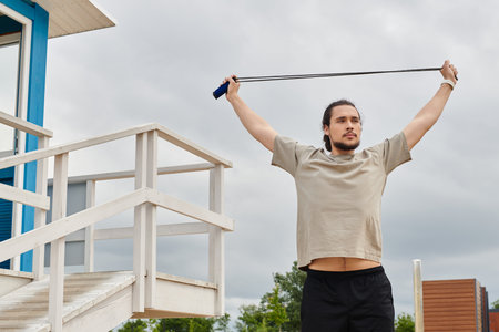 Athletic man is engaged in outdoor workout using a resistance band while enjoying nature.